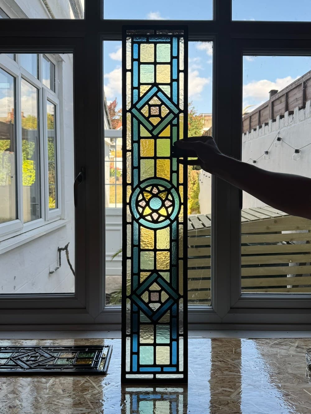A victorian style door panel, held up to catch the light.